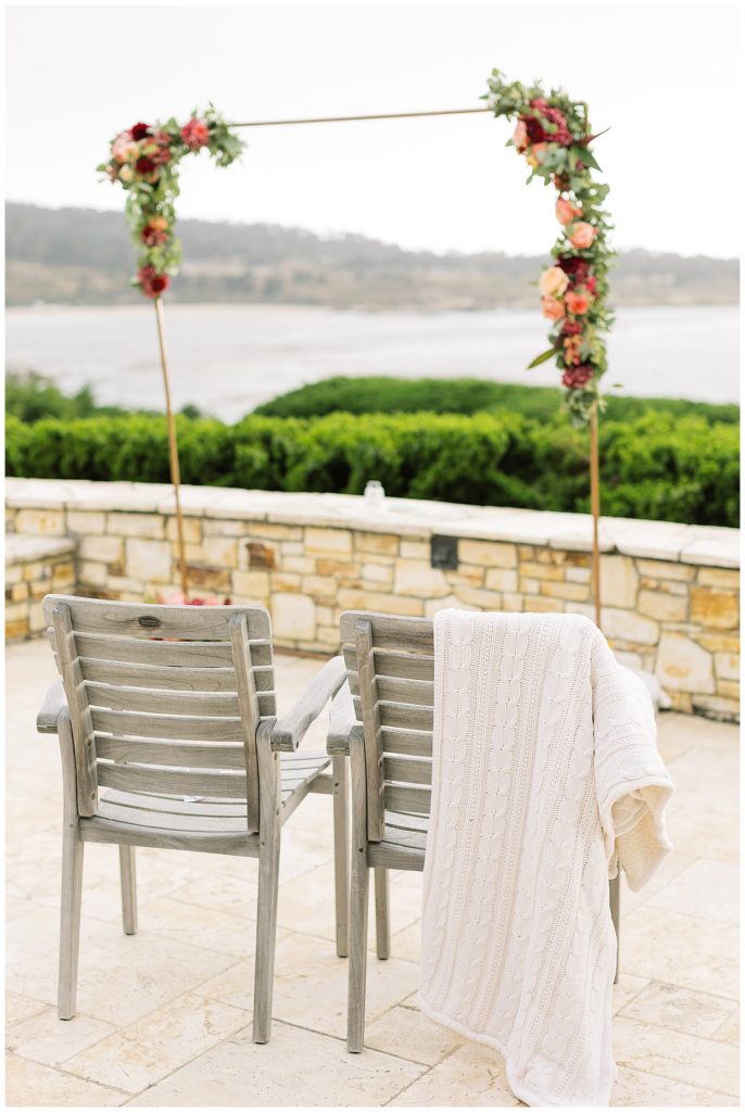 two chairs and a flower garland overlooking the beach at Carmel