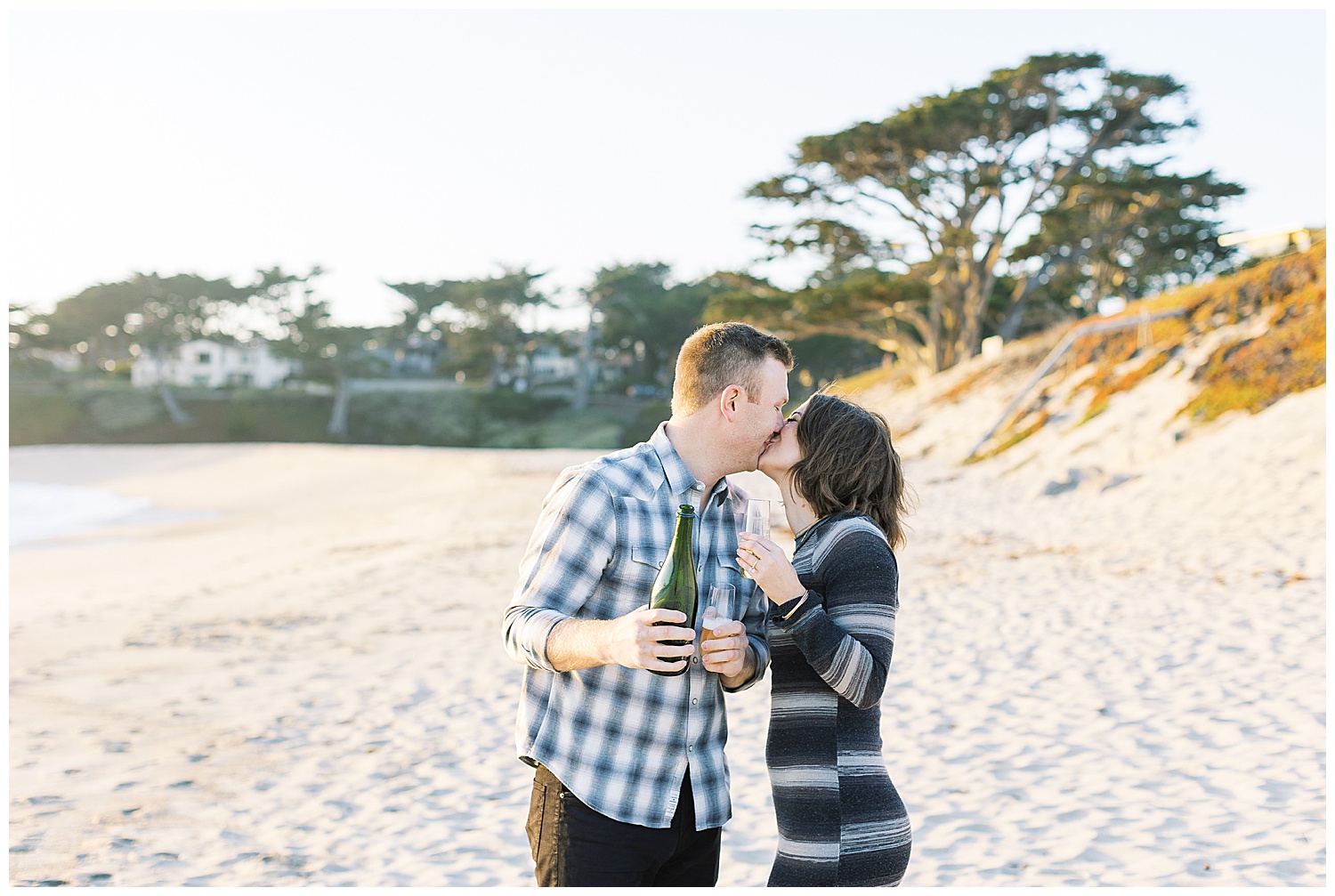 Carmel by the Sea engagement session photo of the couple sharing a kiss and champagne by film photographer AGS Photo Art