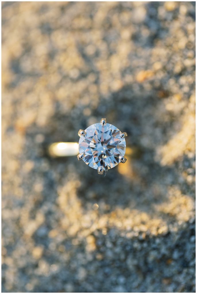 photo of Carmel by the Sea engagement ring in the sand by film photographer AGS Photo Art