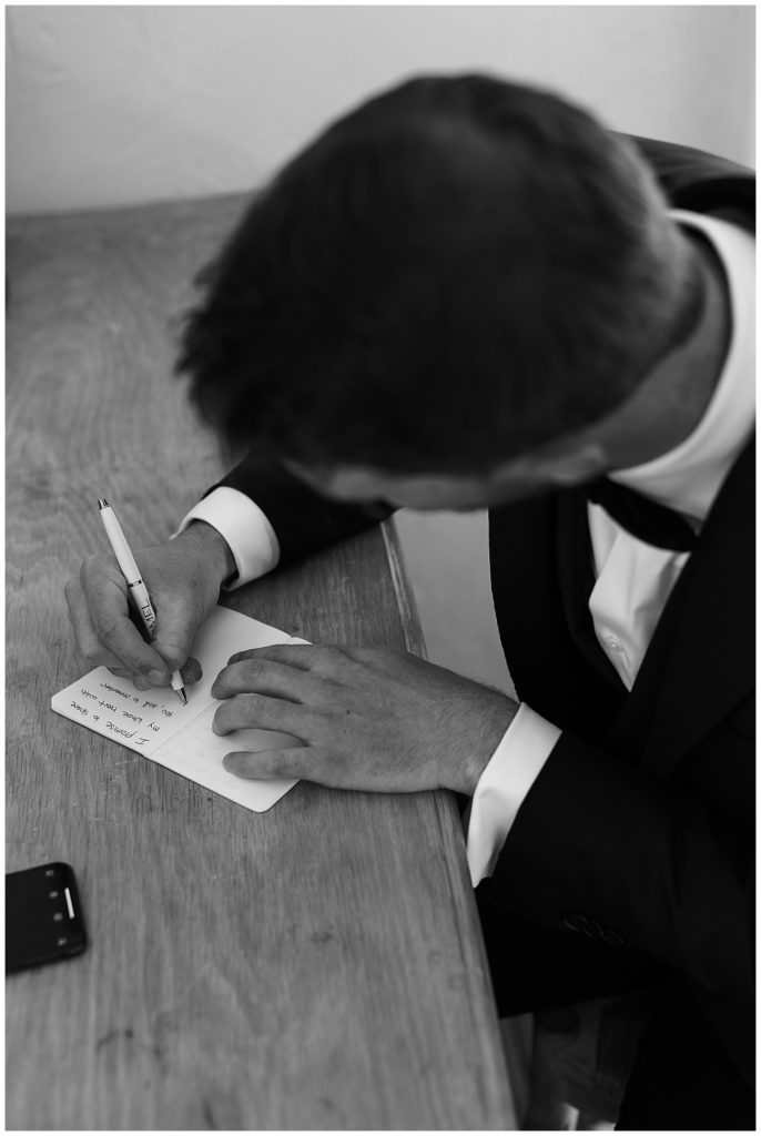 black and white portrait of the groom writing his vows