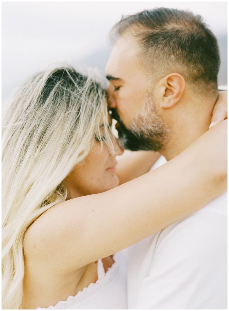 intimate Big Sur anniversary session portrait of the couple embracing each other and touching their foreheads together by film photographer AGS Photo Art