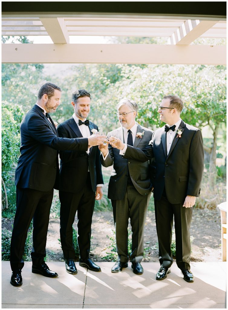 photo of the groom and his groomsmen toasting his signature drink