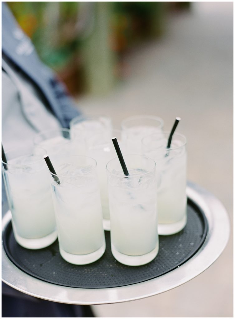 bride and groom's specialty drinks in tall glasses with black paper straws