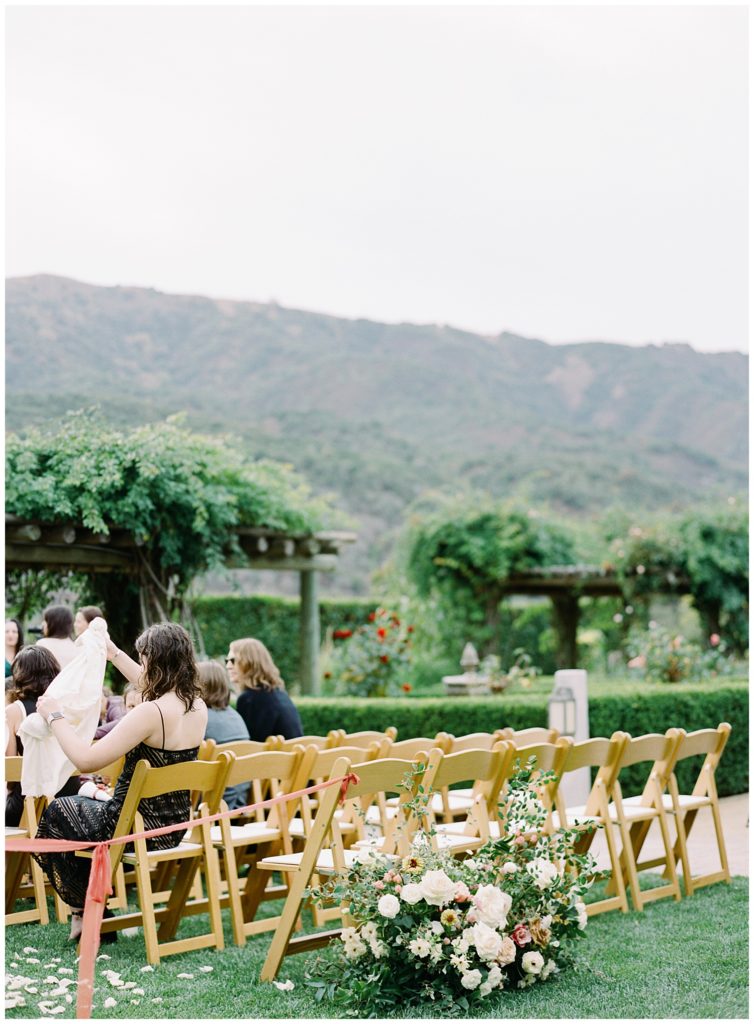 outdoor rose garden wedding ceremony lined with Gavita Flora flowers and ribbons