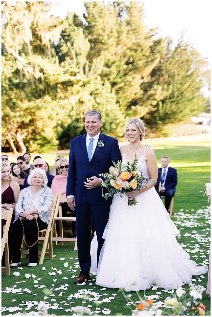 photo of the smiling bride walking down the aisle with her dad on her arm by film photographer AGS Photo Art