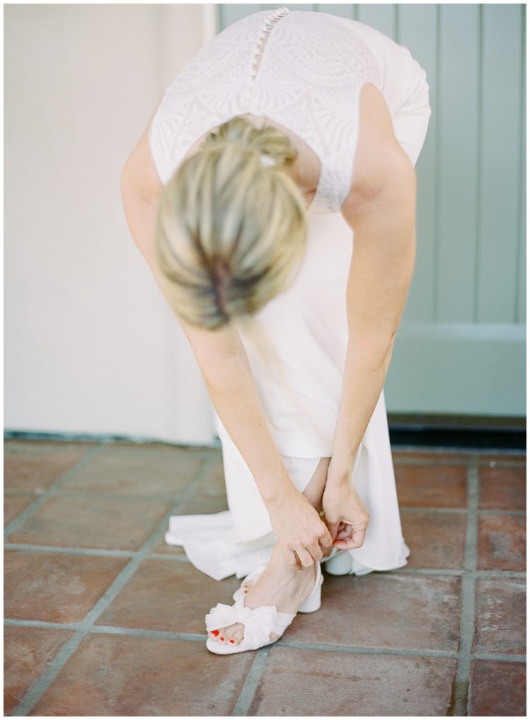 the bride getting ready for her MPCC Beach House intimate wedding and putting on her Loeffler Randall heels