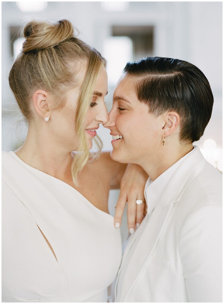 two brides touching their noses together and smiling