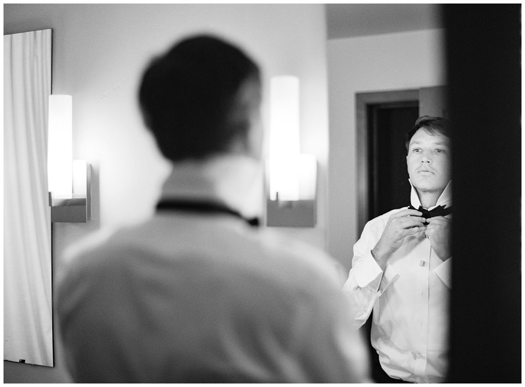 black and white photo of the groom getting ready for his Wind & Sea Estate Big Sur wedding