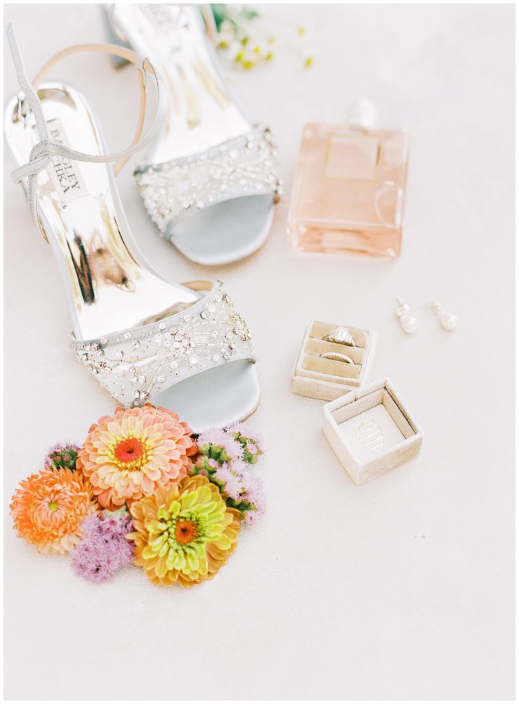 Wind & Sea Estate Big Sur wedding bride's details: shoes by Badgley Mischka, florals by Big Sur Flowers, pearl earrings, pink glass perfume, and family heirloom ring