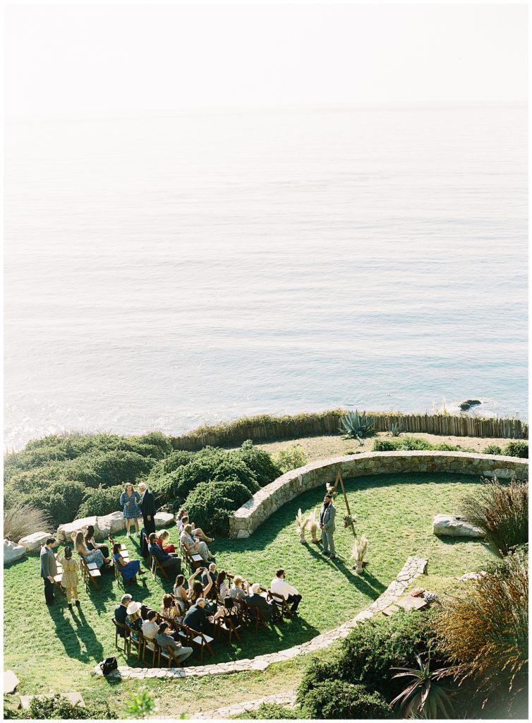 faraway shot of the Wind & Sea Estate Big Sur wedding ceremony featuring the guests and officiant by film photographer AGS Photo Art