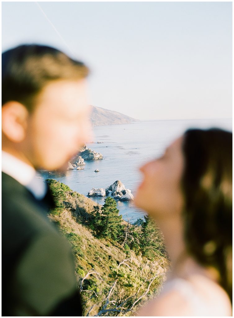 background focused photo of Wind & Sea Estate Big Sur wedding with the married couple out of focus in the foreground by film photographer AGS Photo Art