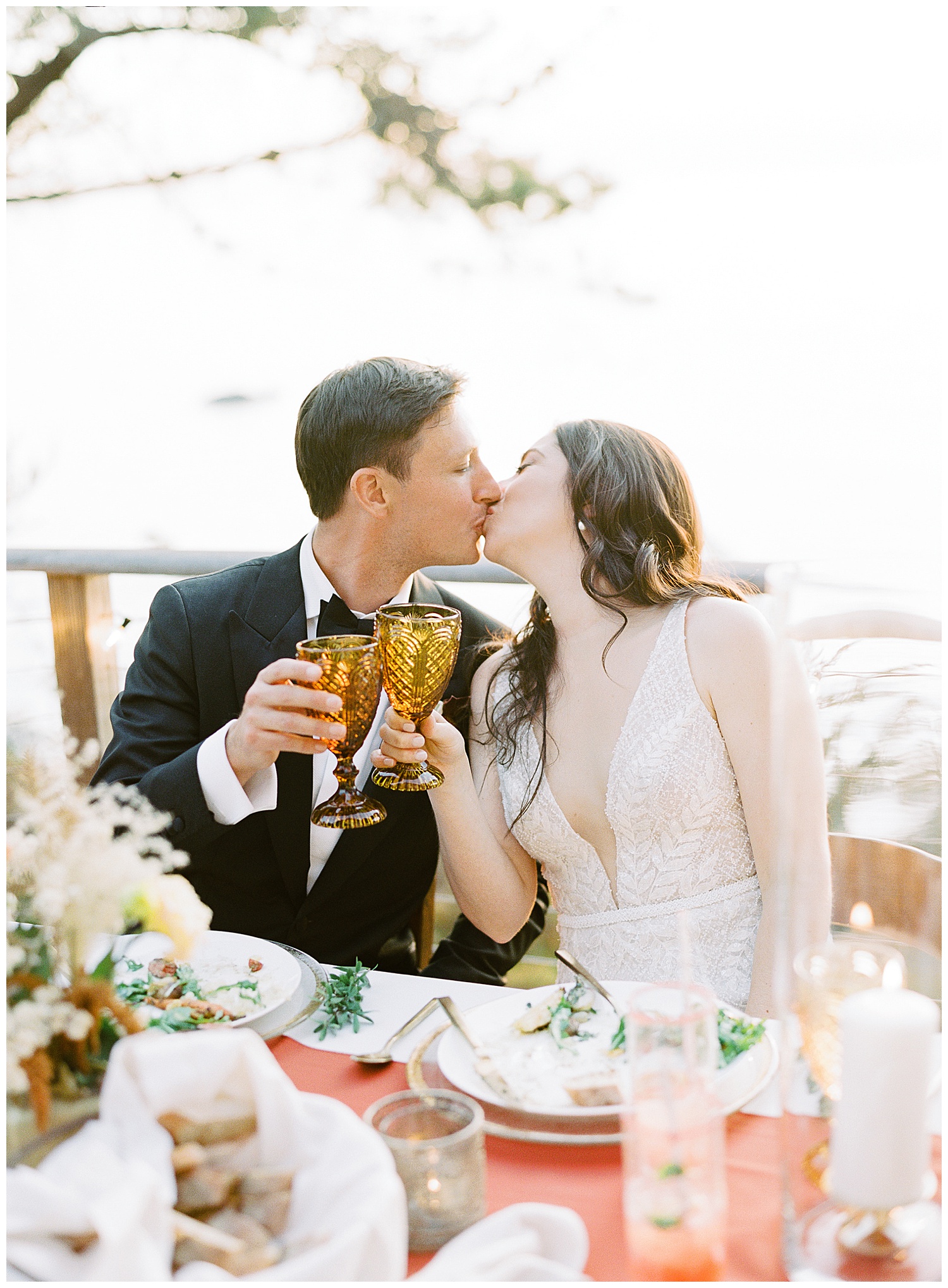 photo of the bride and groom toasting their drinks and sharing a kiss by film photographer AGS Photo Art