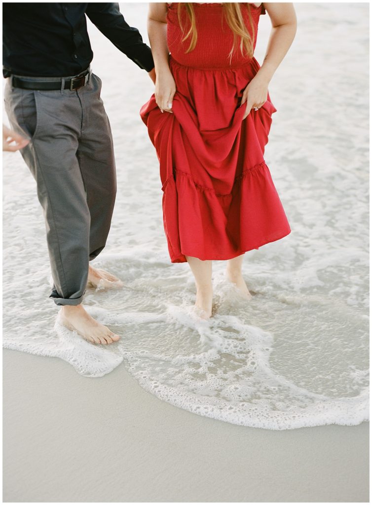 couple playing in the water during their Pebble Beach engagement
