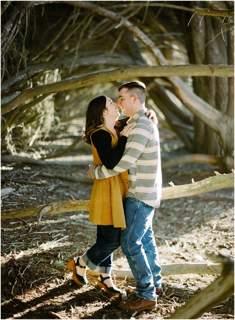 couple brushes their noses together for a sweet engagement portrait in Big Sur