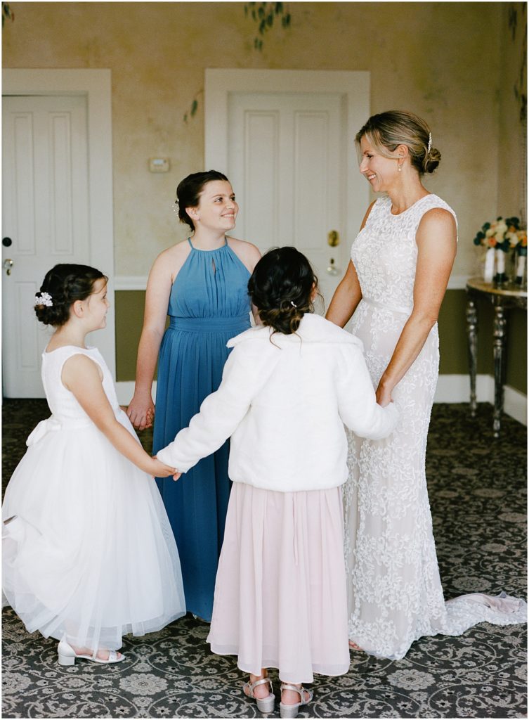 portrait of the bride holding hands with her three daughters