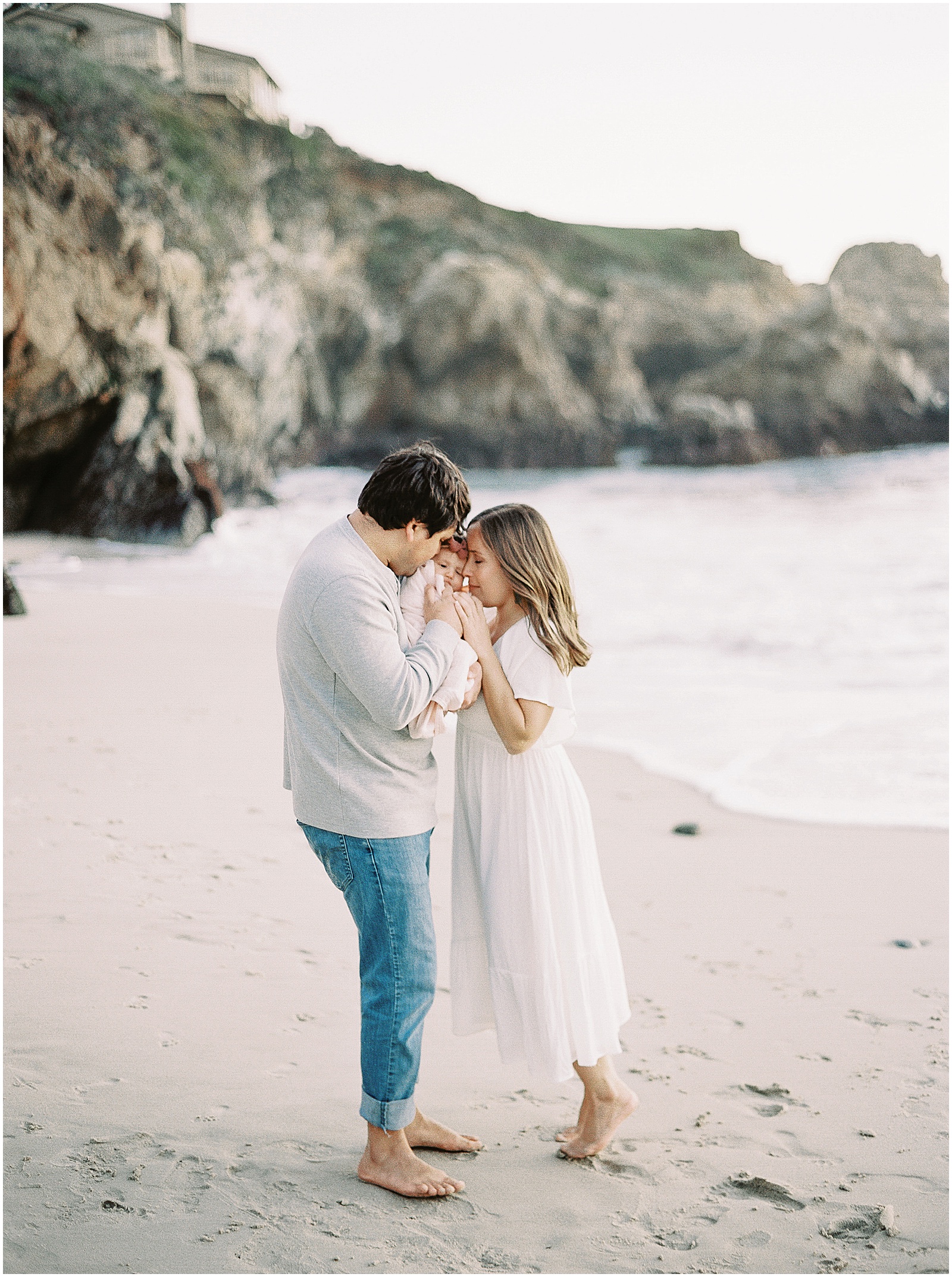 portrait of a mother and father snuggling their newborn during Big Sur family shoot