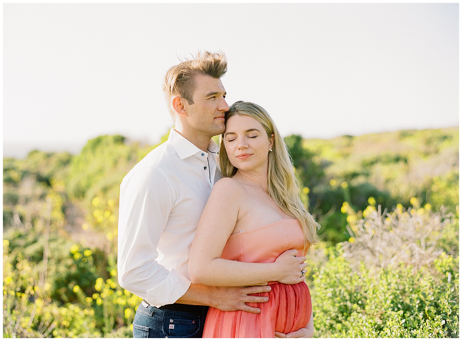 a couple holding one another during Big Sur Maternity Shoot