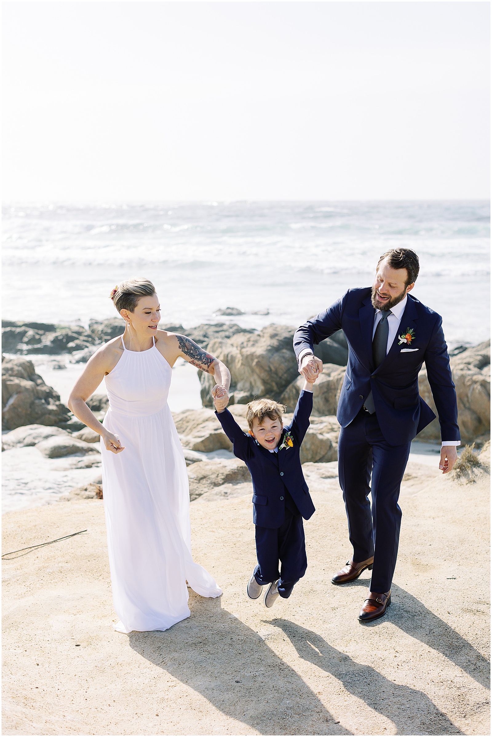 portrait of bride and groom swinging their son