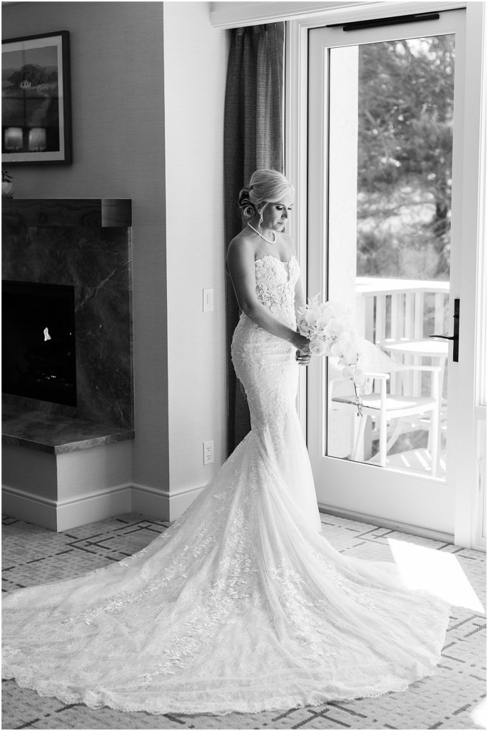 portrait of bride standing looking outside window by film photographer AGS Photo Art