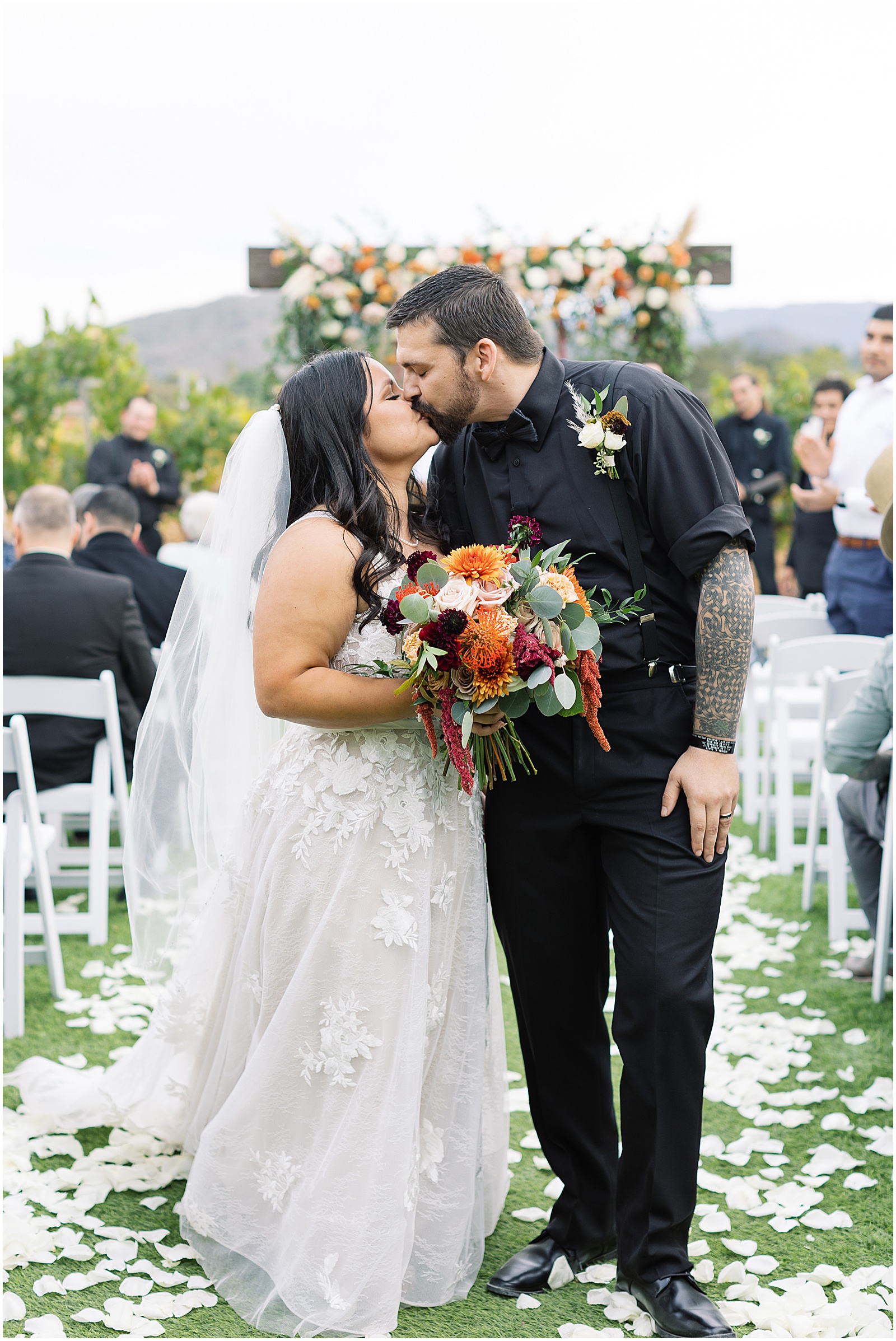 portrait of couple sharing kiss exiting ceremony by film photographer AGS Photo Art