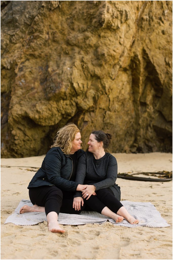 portrait of couple sitting on picnic blanket on the beach by film photographer AGS Photo Art