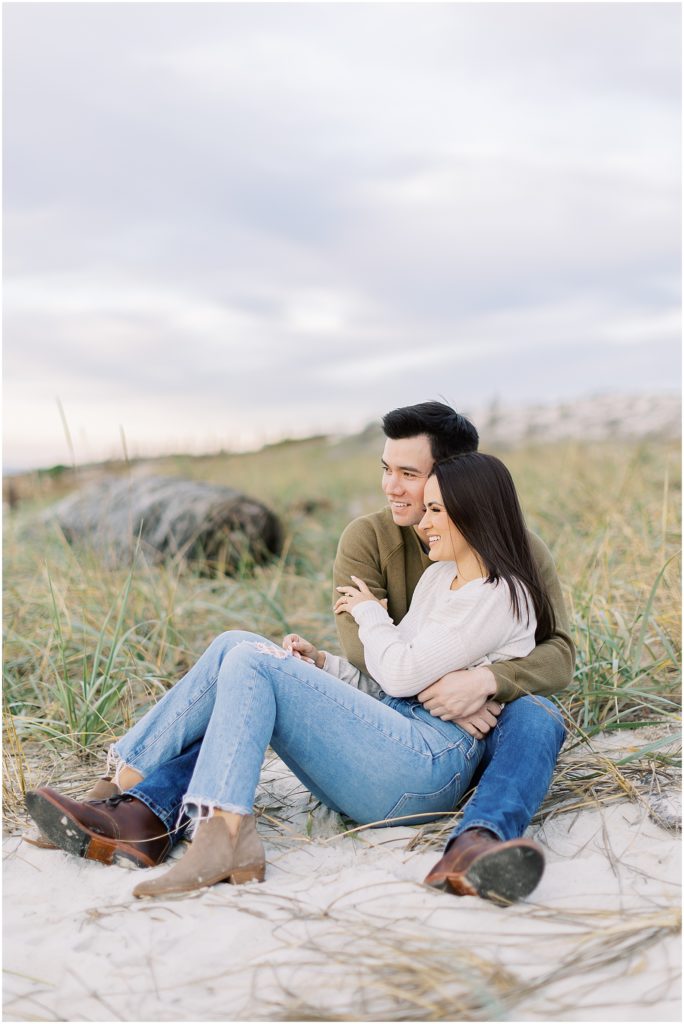 portrait of couple sitting on the beach looking at the ocean by film photographer AGS Photo Art