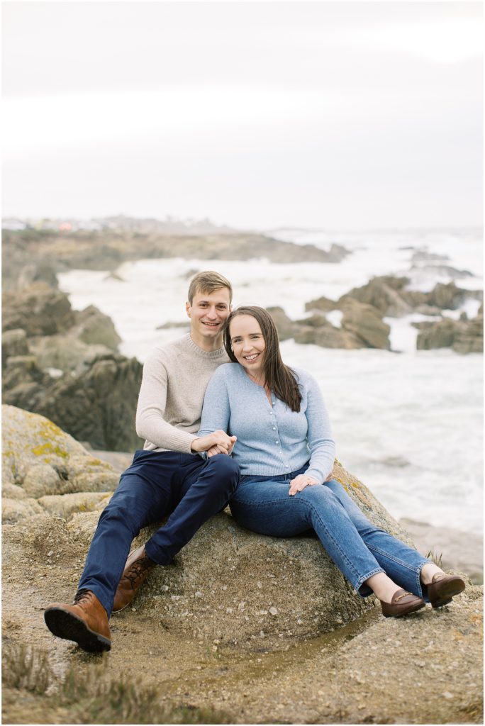 portrait of couple sitting on rock by the coast by film photographer AGS Photo Art