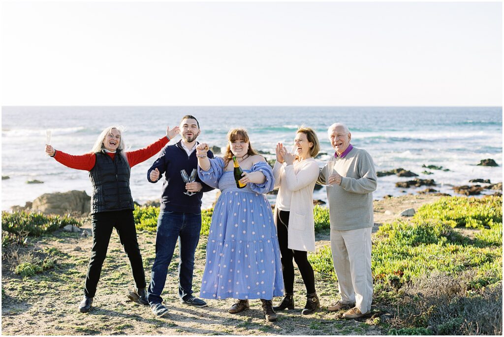 photo of family of five celebrating by popping champagne, after a surprise proposal in Big Sur