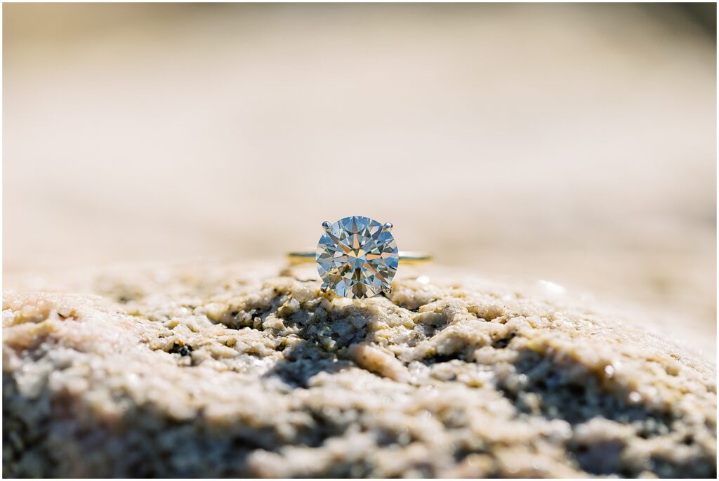 close up detail shot of an engagement ring placed on a rock, at a surprise proposal in Big Sur