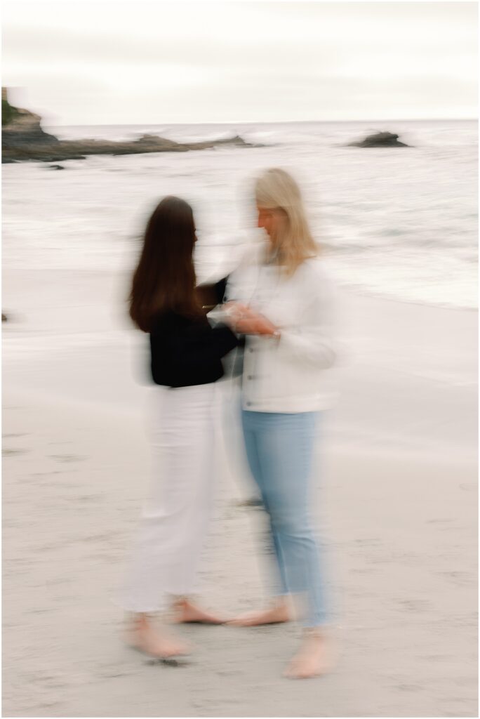 Newly engaged LGBT couple holding each other by the beach shot on film photography AGS Photo Art with aesthetic motion blur