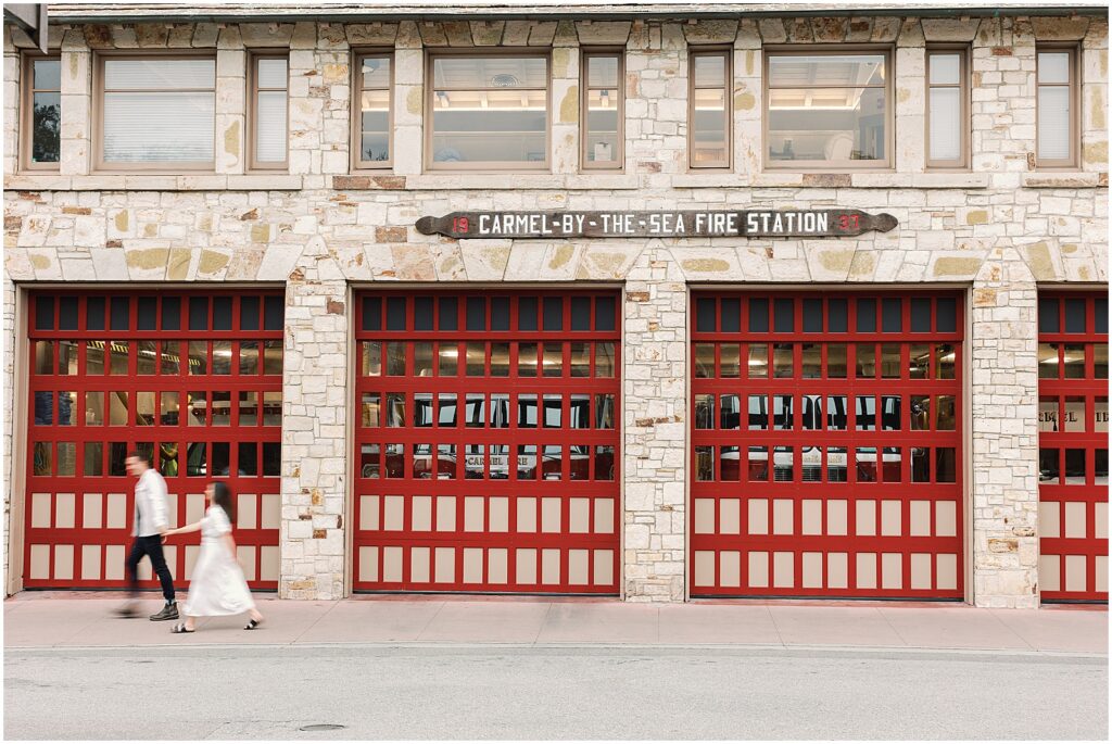 Engaged couple walks by the Carmel-by-the-Sea fire station. Photography by AGS Photo Art