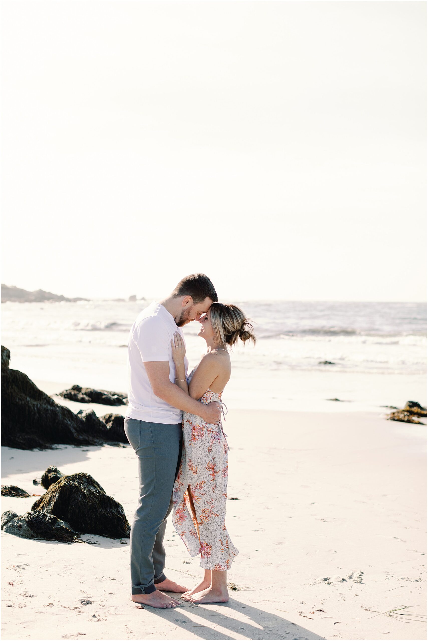 Josh and Tasha share an intimate moment on the sand with the ocean behind them, photographed by Asilomar Beach Proposal Photographer.
