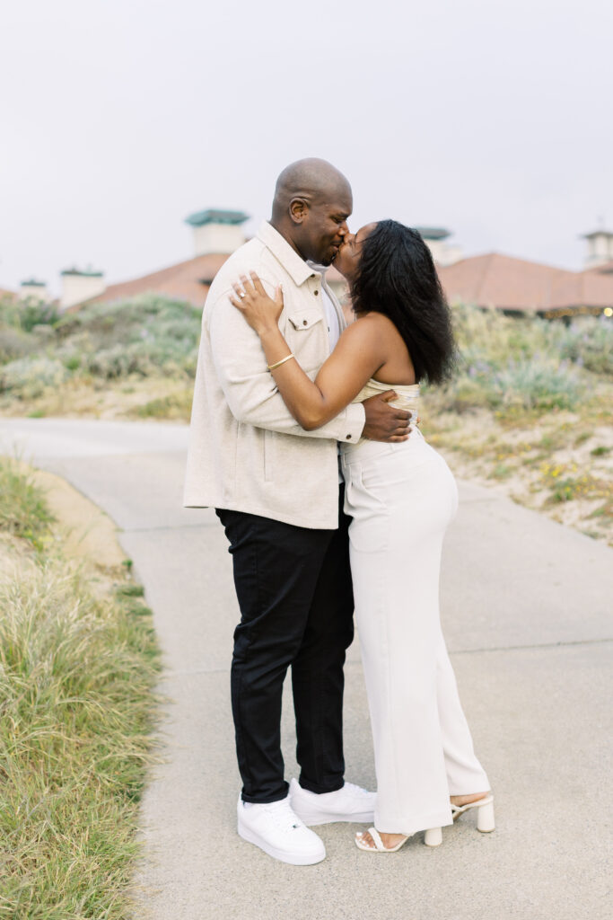 John and Jessica kissing at sunset during their Spanish Bay engagement photos.