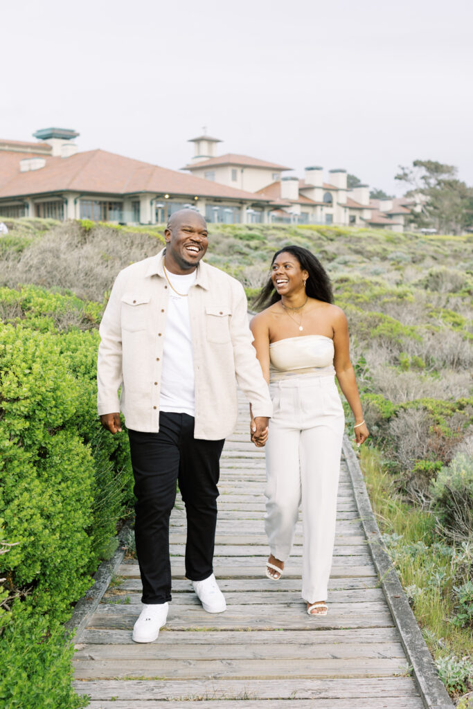 John and Jessica walking hand in hand along Pebble Beach.