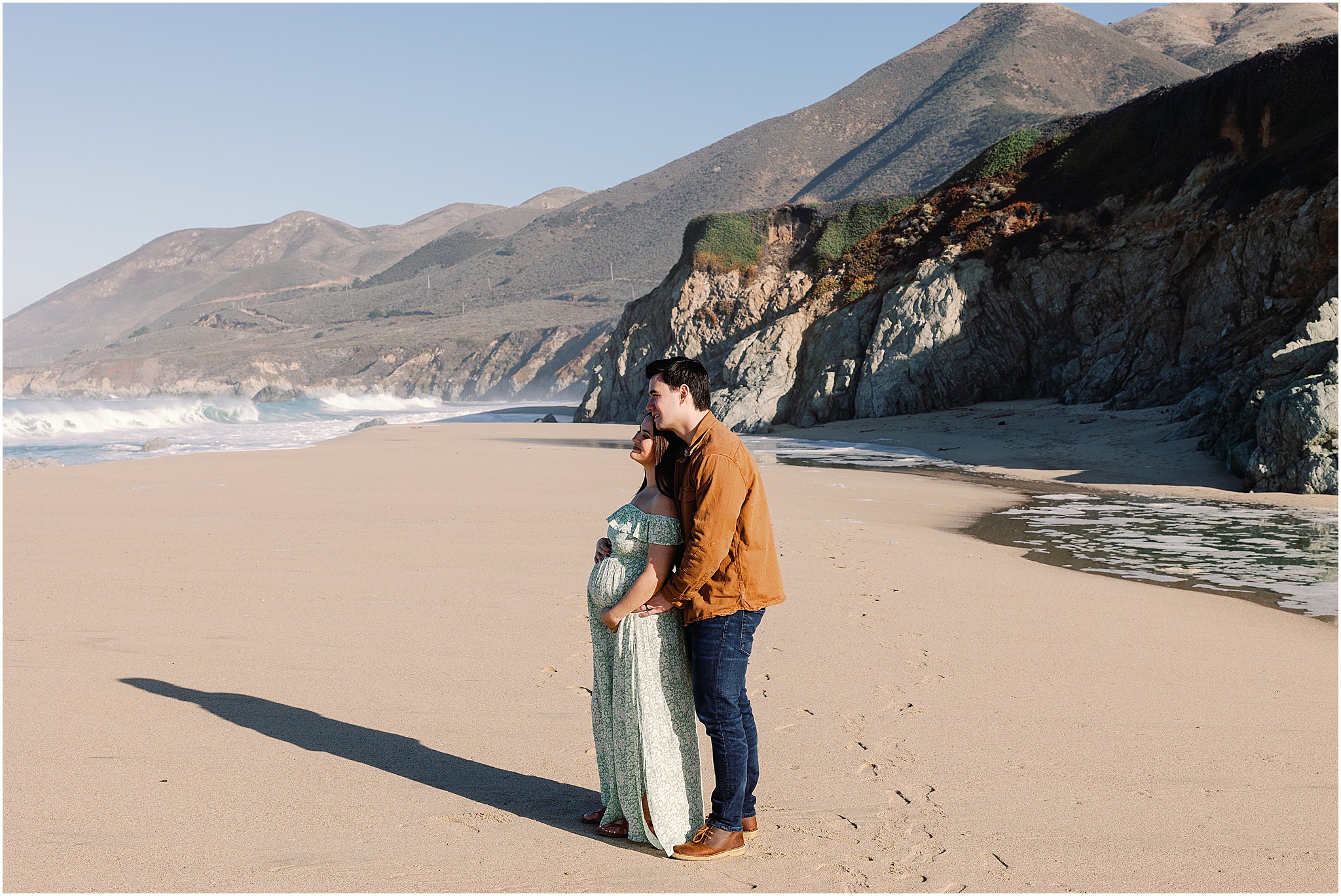 A soft, emotional portrait of Amanda’s hands resting over her belly while embraced by Cory during maternity photography in Big Sur.