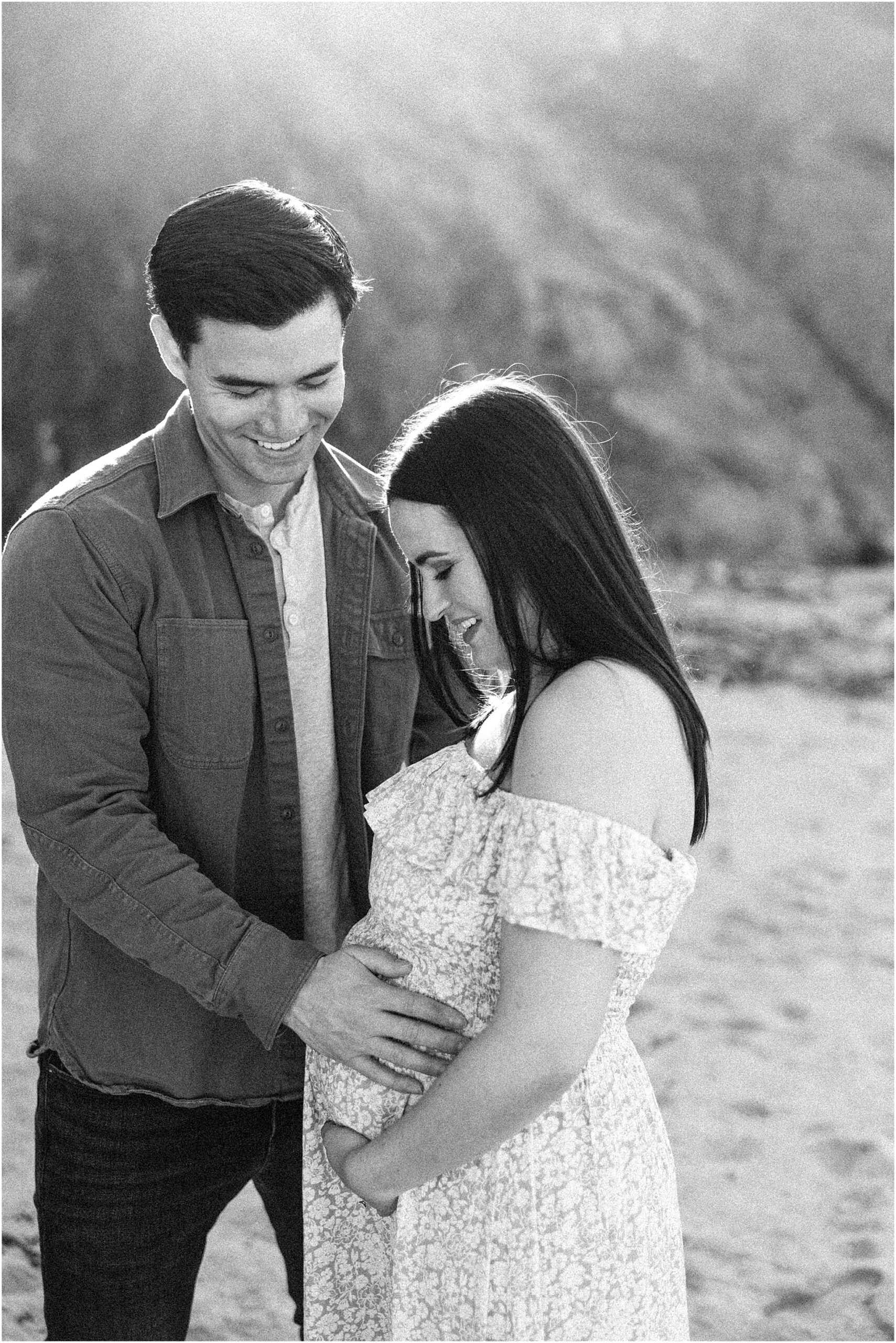 Cory smiles as he looks at Amanda during their maternity photoshoot in Big Sur.