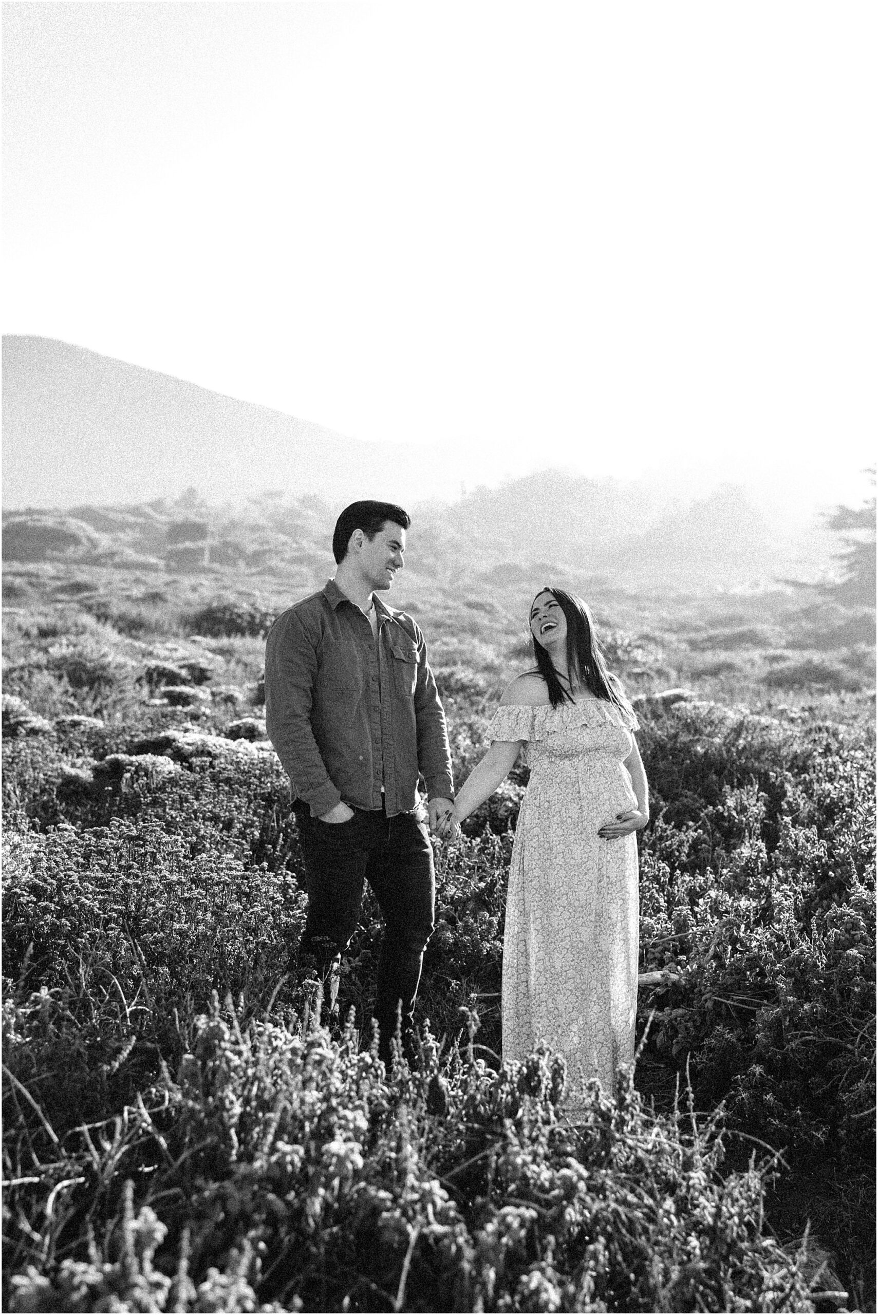 Amanda and Cory walking hand in hand along the cliffs during a Big Sur maternity session.