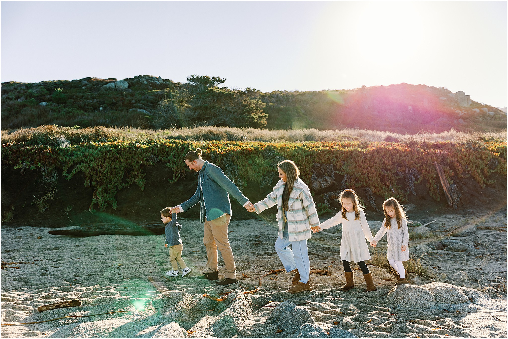 The Zeller Family walking along the shoreline at Carmel Beach during their photo session.