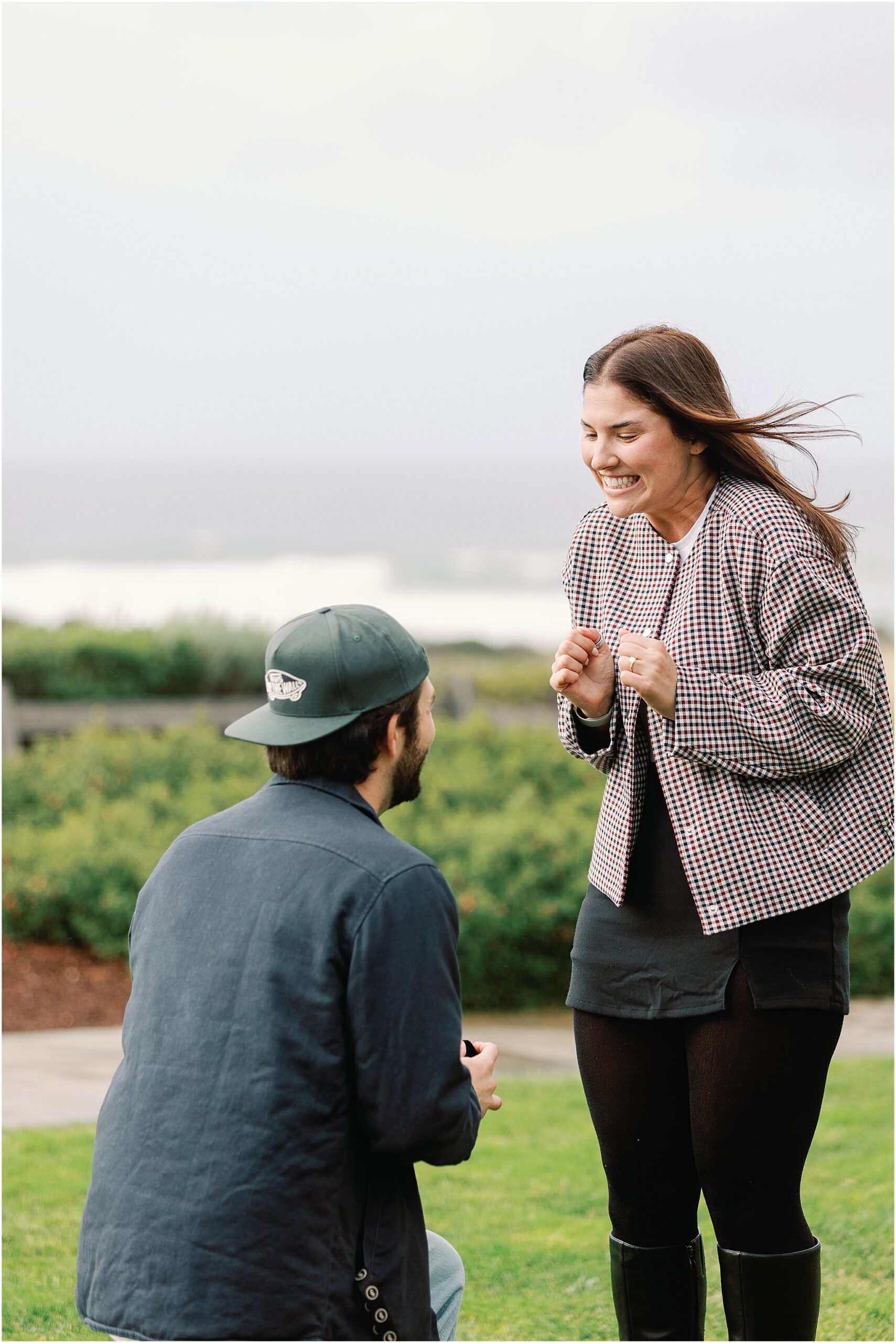 Calvin proposing to Camille during their Spanish Bay Beach proposal at sunset.