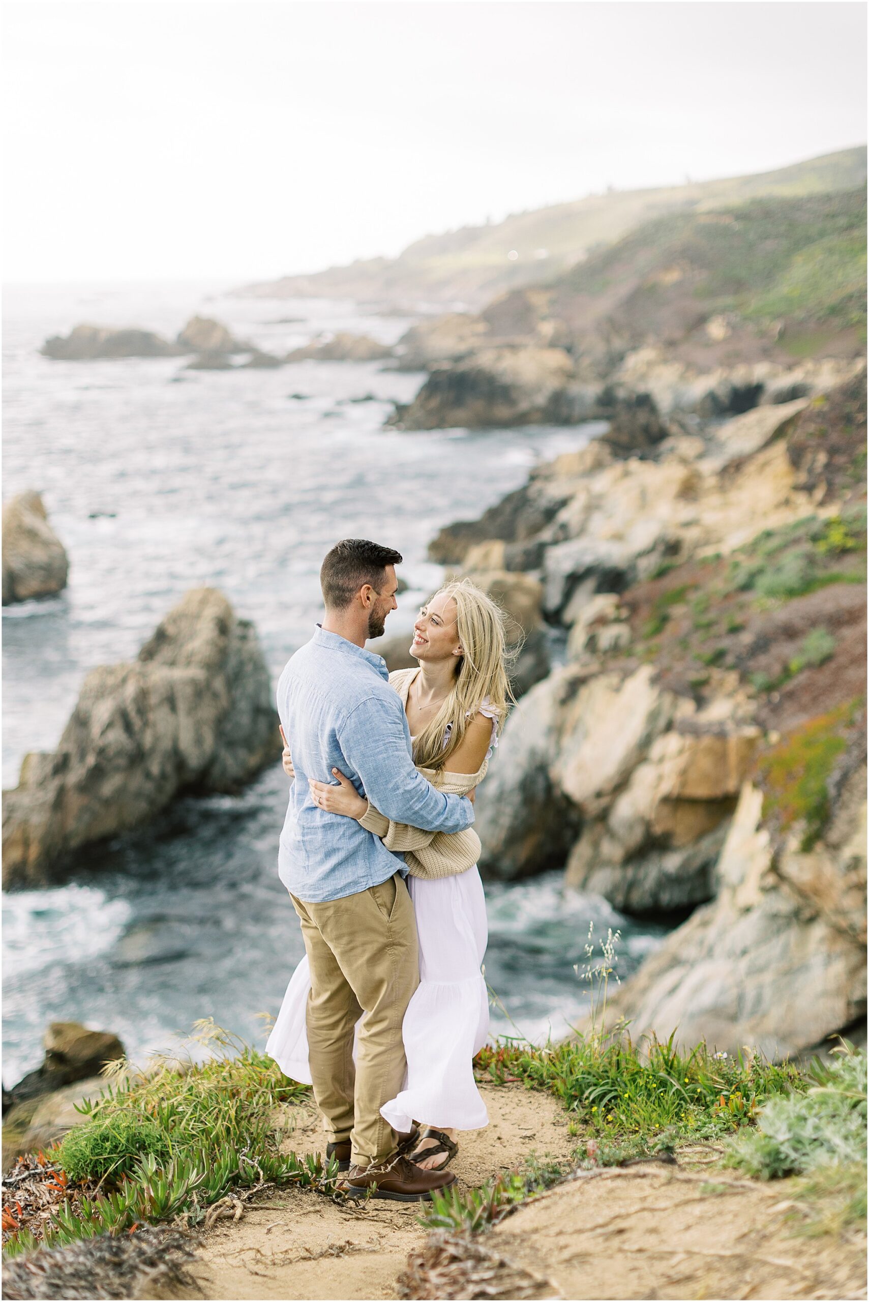 Couple standing together on the cliffs during their romantic Big Sur engagement session