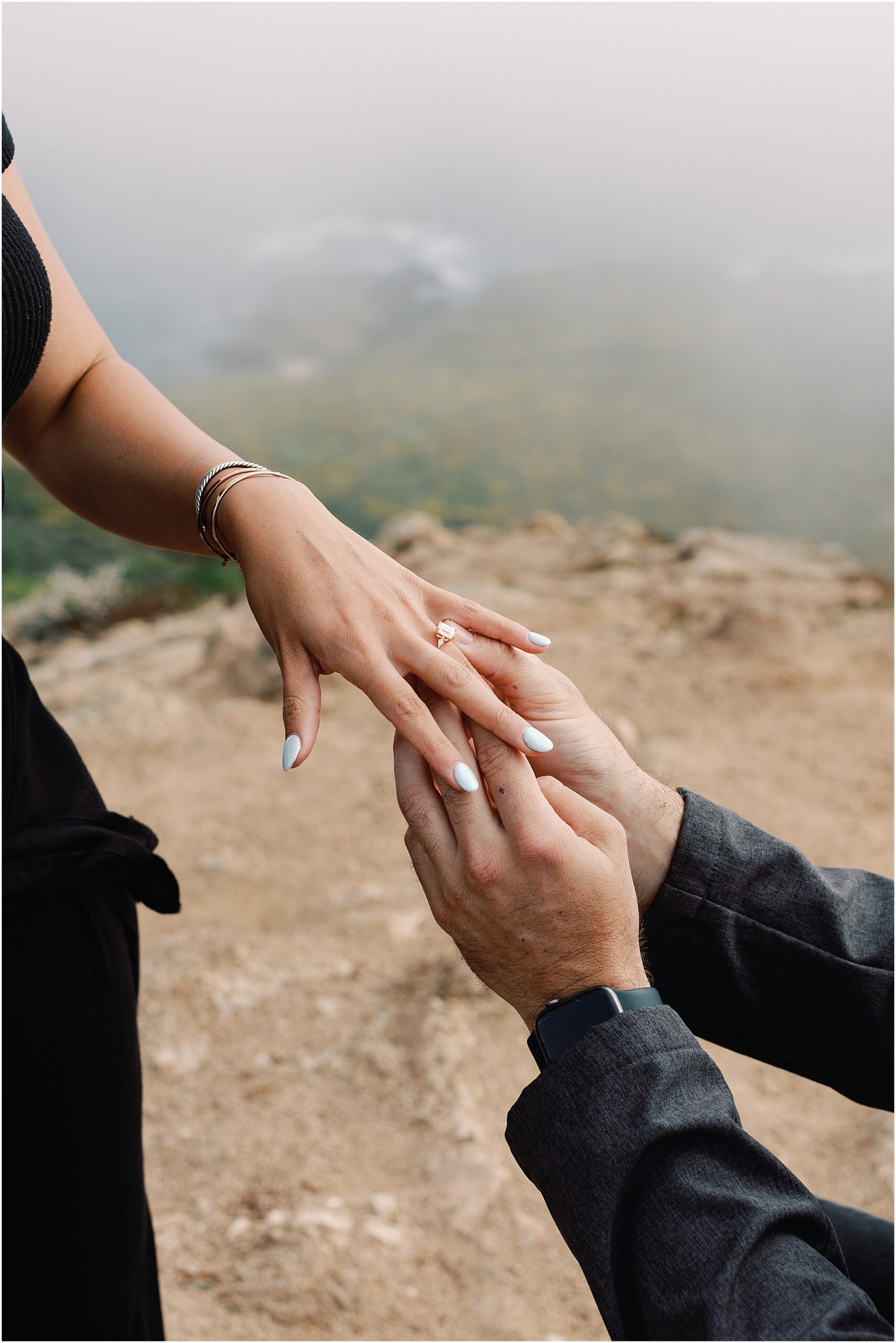 Close up of Laurens hand showing her emerald cut engagement ring.