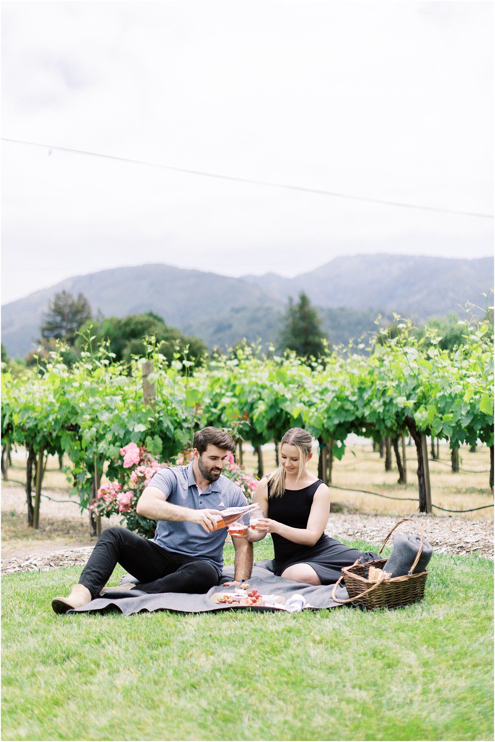 Picnic setup with wine and a couple before their Folktale Winery surprise proposal in Carmel.