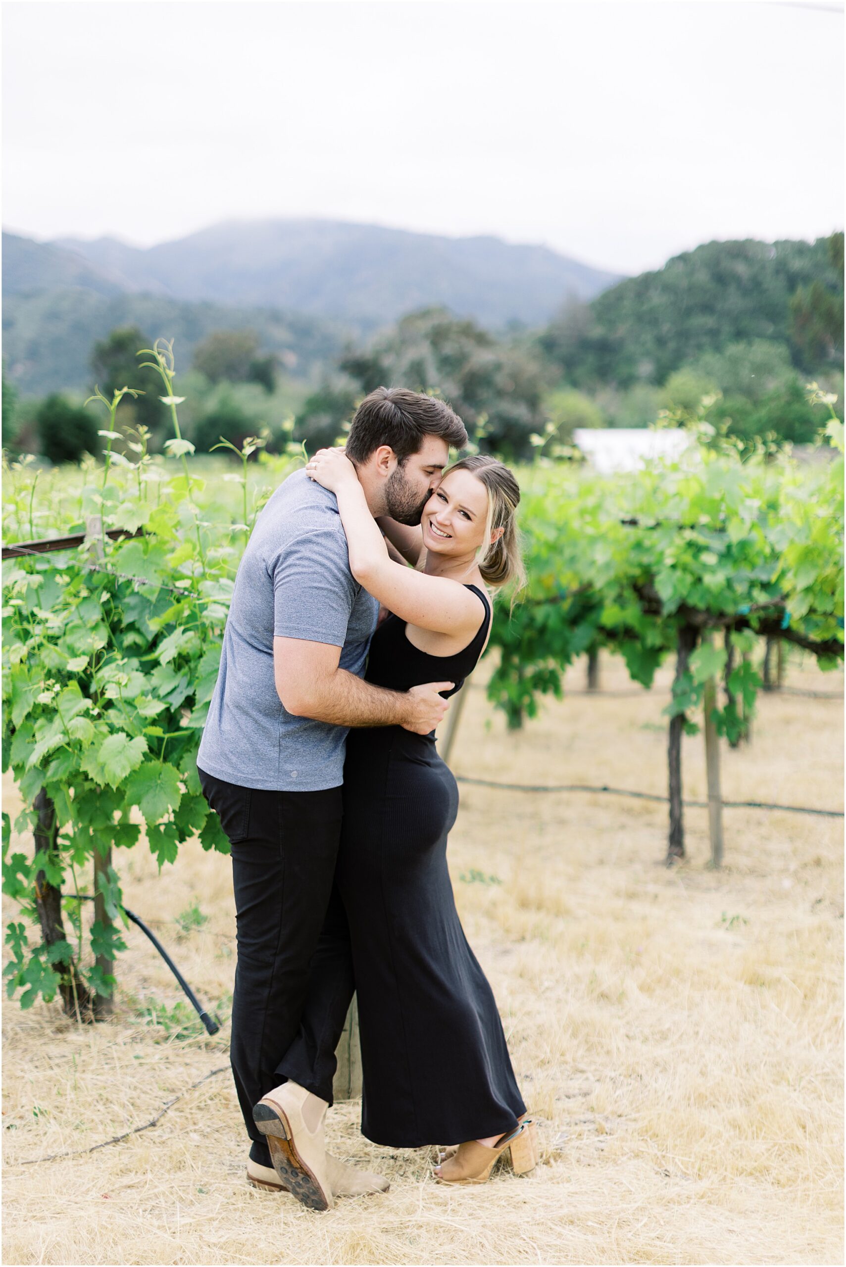 Engaged couple cuddling in the vines during a Folktale Winery surprise proposal.