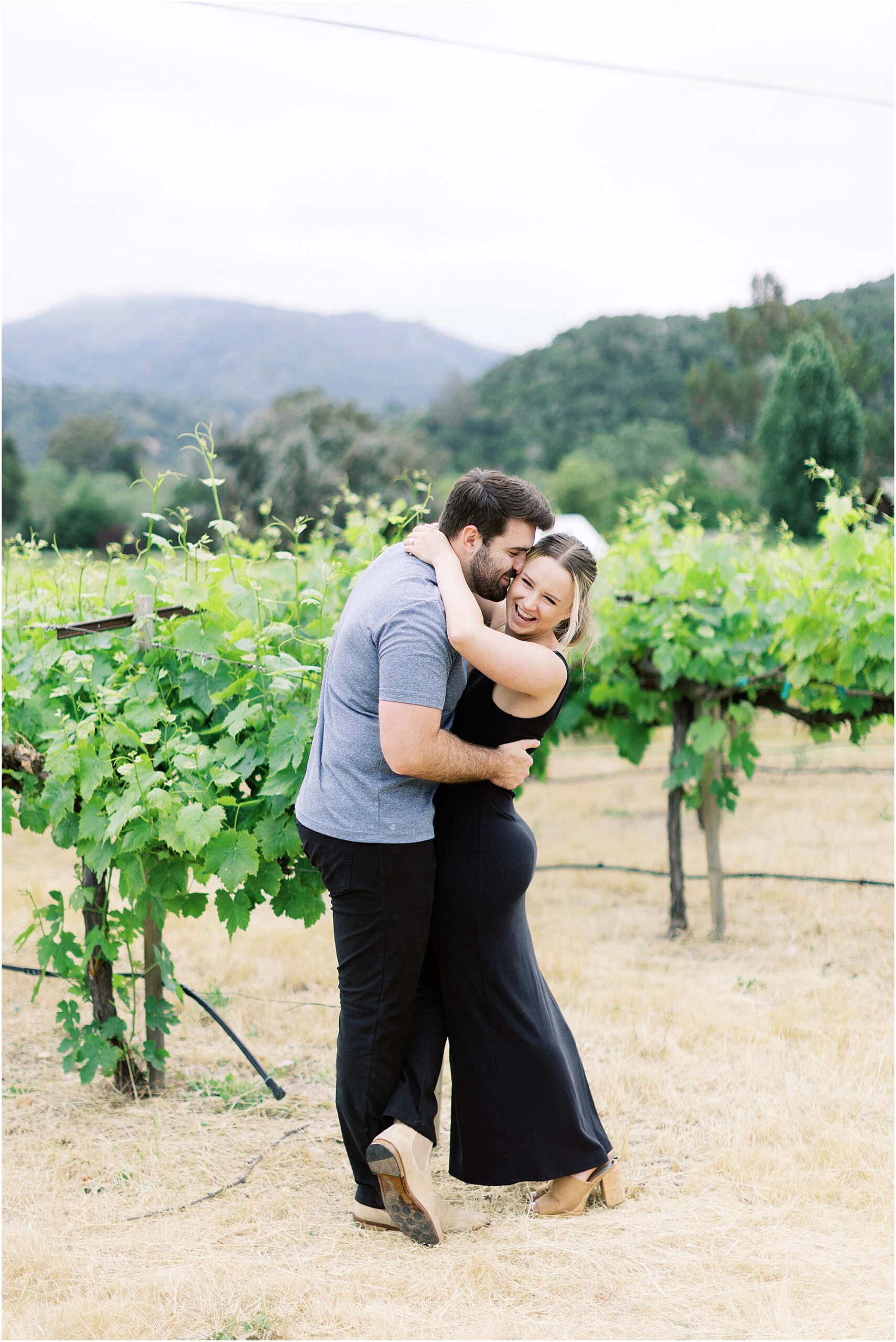 Couple hugging in the vines during intimate vineyard engagement photos.