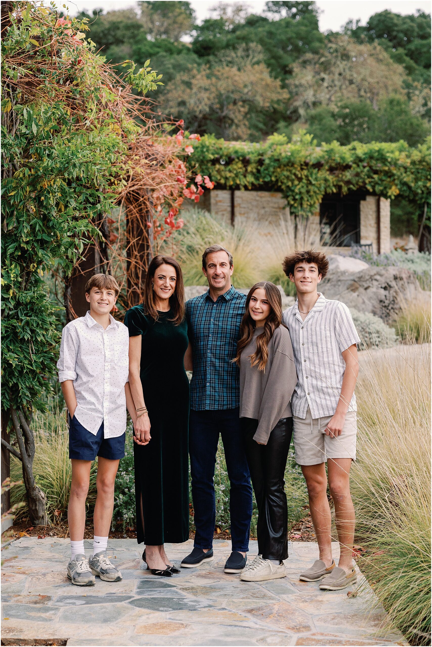 Family gathered in a sunlit courtyard during their Santa Lucia Preserve photography session.