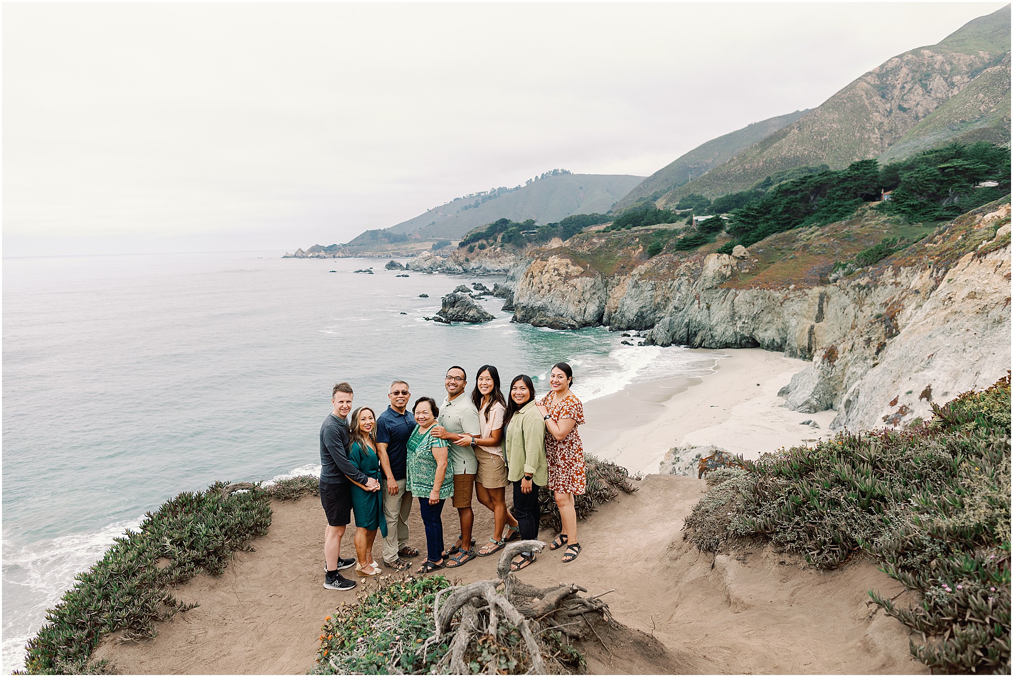 Rozul Family group portrait on the Big Sur shoreline with ocean cliffs in the background.