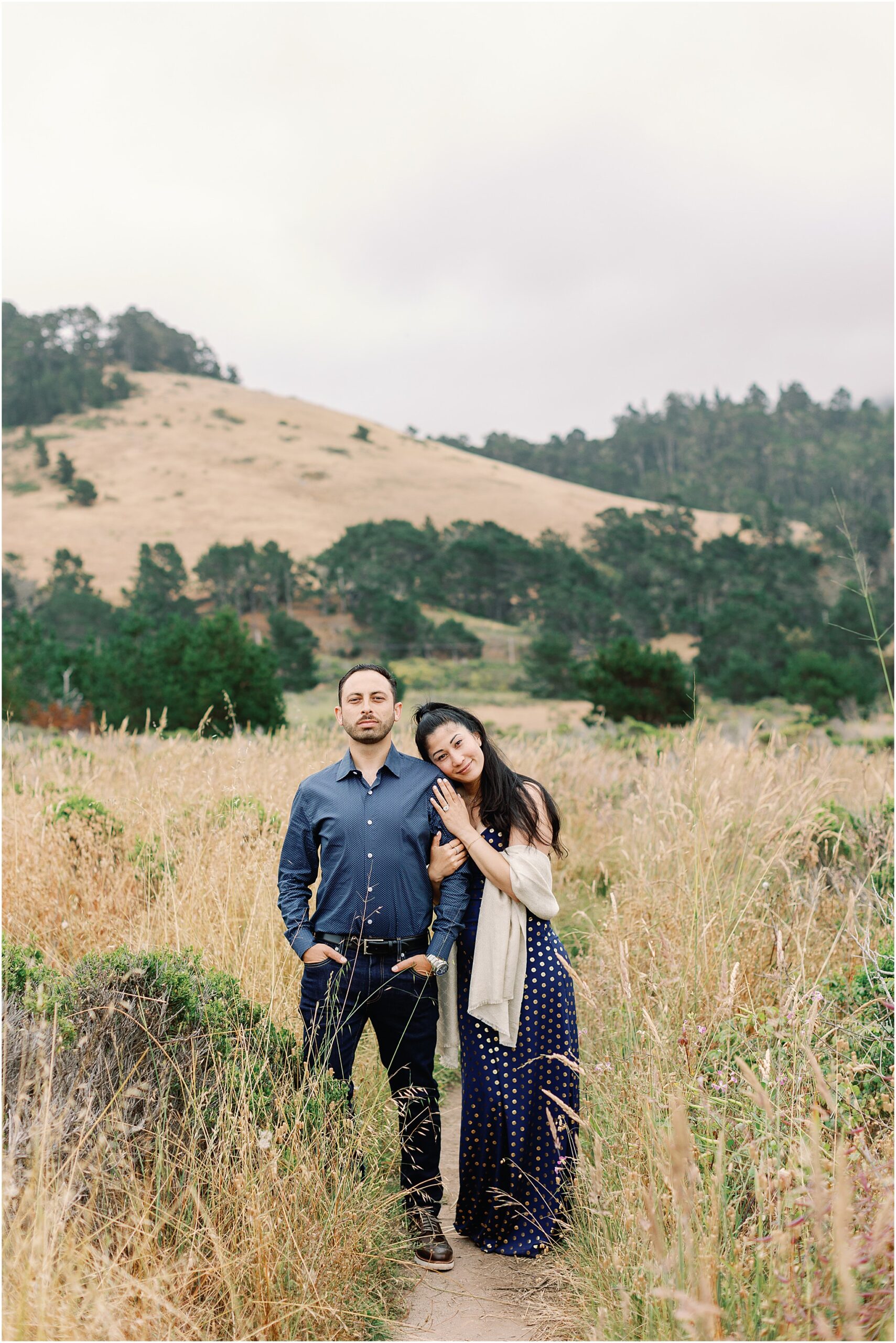 Portrait of the couple smiling after their coastal engagement.