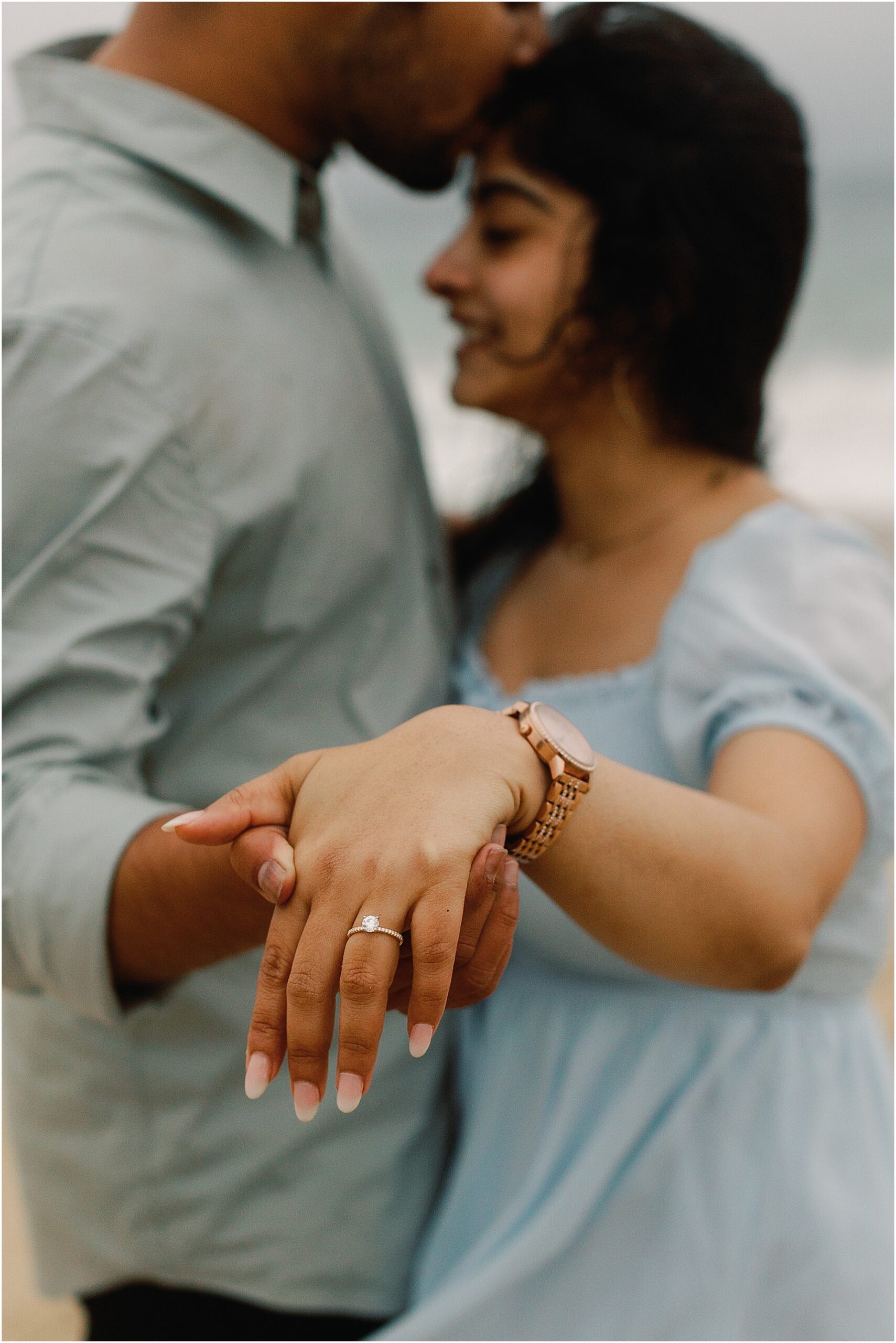 Close up of engagement ring sparkling in natural light after the proposal on the beach.