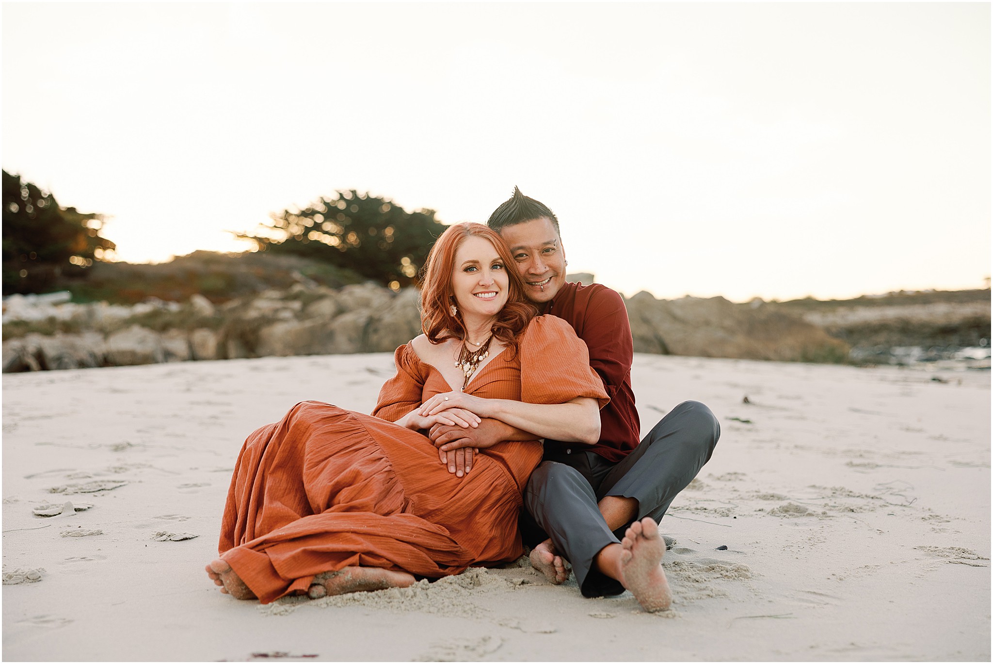 Couple embracing during Big Sur beach engagement session at sunset.