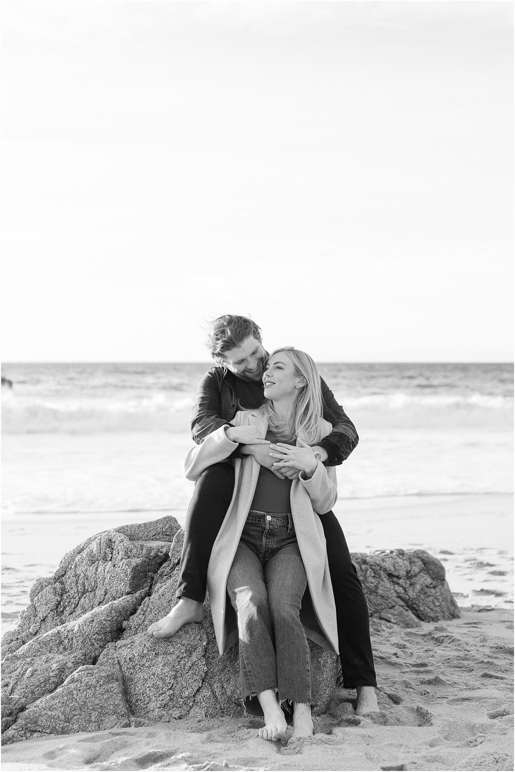 Couple celebrating engagement on Big Sur beach shot in black and white.